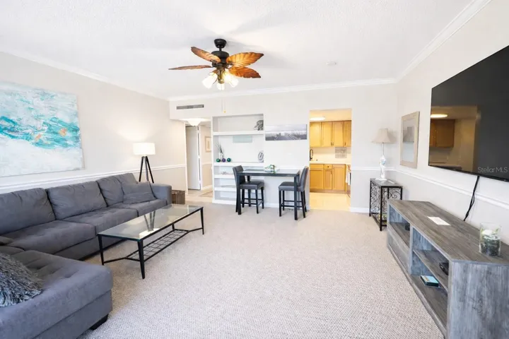 Bright and airy living room featuring an impressive 82” Sony smart TV, custom finishes, and vibrant coastal design.