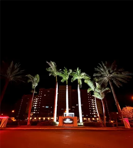 Beautifully manicured grounds and a welcoming, tropical entrance at night.