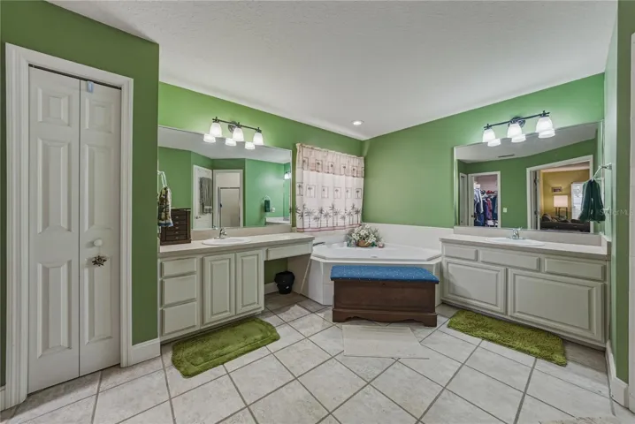 The primary bath has a linen closet, dual vanities, and a corner jetted tub.