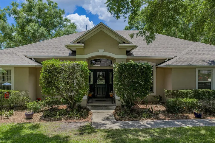 The covered front porch leads to the leaded glass front door.