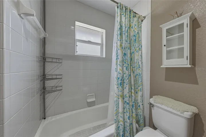 The guest bathroom has a privacy glass window in the combination tub and shower.
