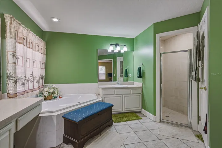 The primary bath has a stall shower with glass shower door.