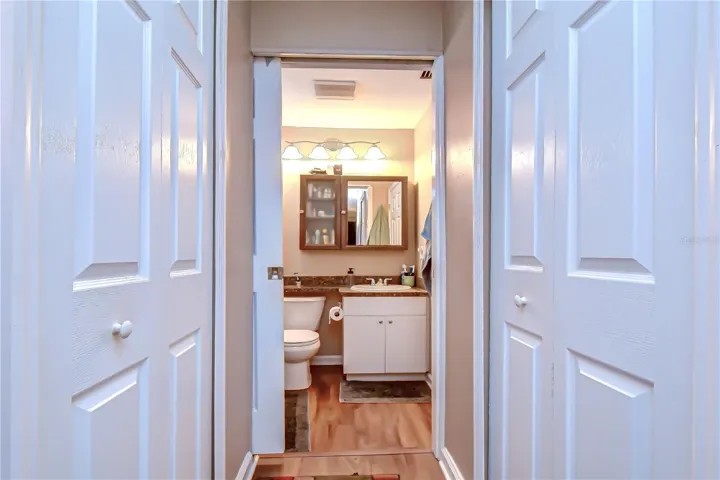 Entrance to primary bathroom with dual closets on either side.