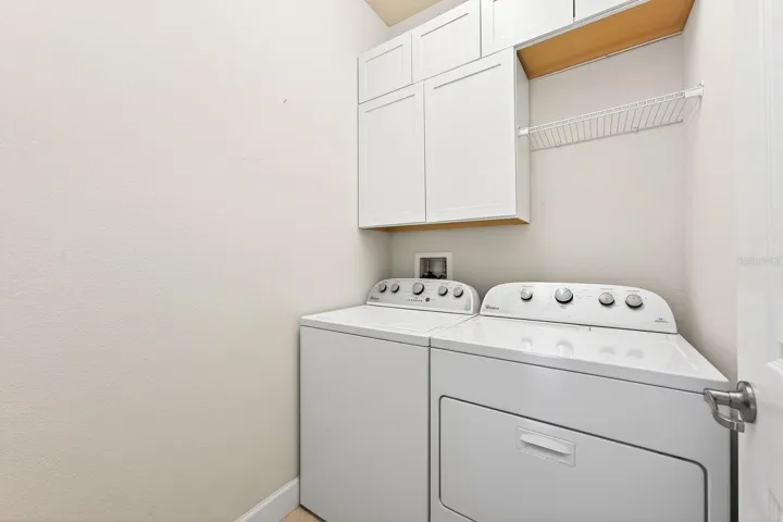 A DEDICATED LAUNDRY ROOM with cabinetry plus included washer and dryer adds everyday convenience.