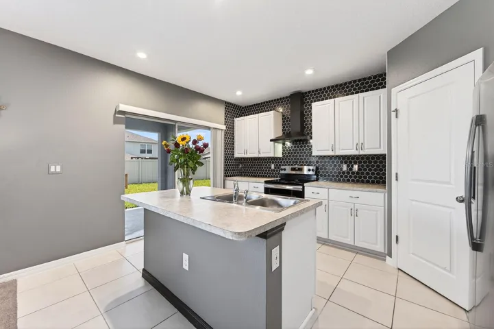 With room for counter-height stools, the Kitchen island serves as a comfortable spot for quick meals or gathering with guests.