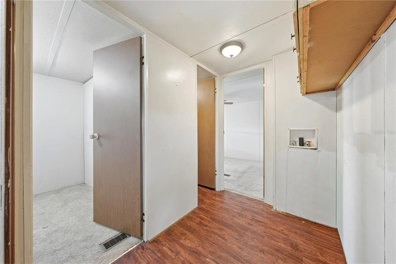 Laundry connections in hallway across from bathroom