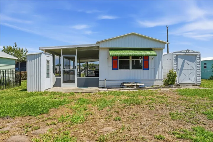 Rear view of home with 2 sheds