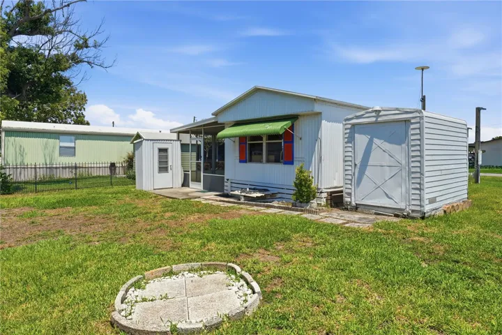 Rear view of home with 2 sheds