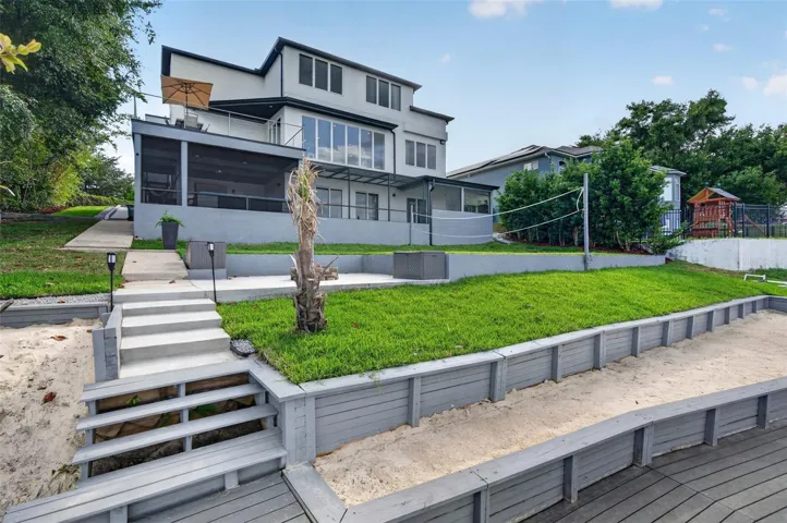 Casalago’s lakefront setting feels like a private resort, with a sandy beach area, volleyball court, firepit space, two docks, and multiple outdoor living zones designed for entertaining, relaxing, and recreation.