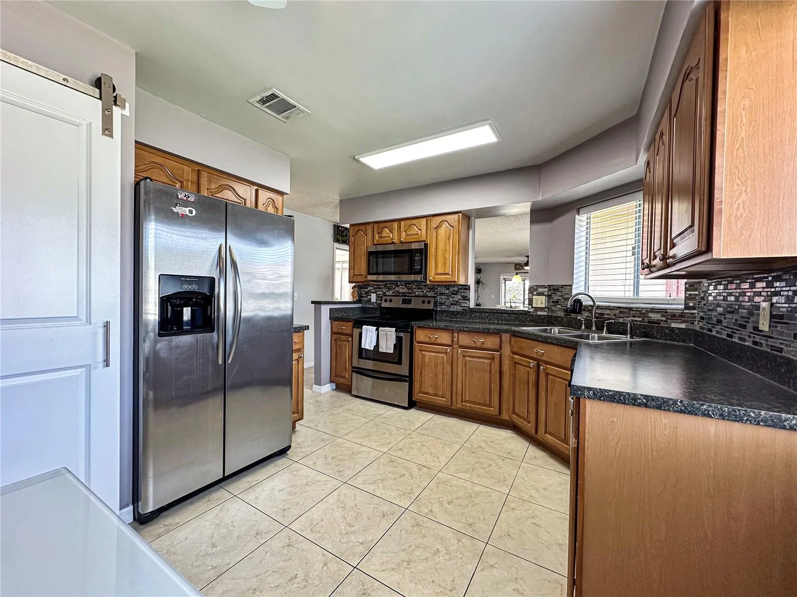 Kitchen view with the solid wood cabinets, nice splash, stainless steel appliances, etc.