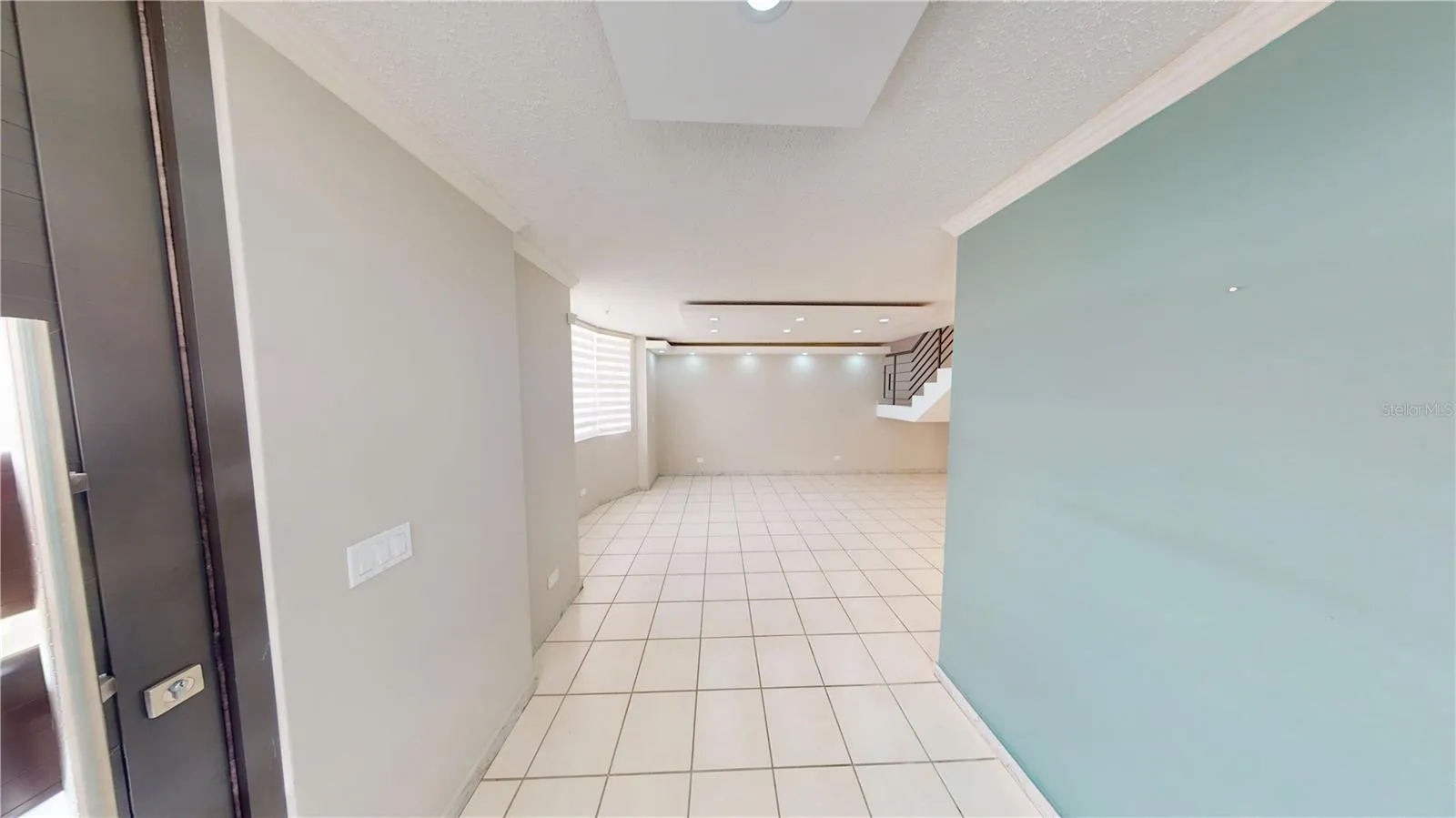 Elegant entrance foyer featuring decorative molding and a modern pivot entry door