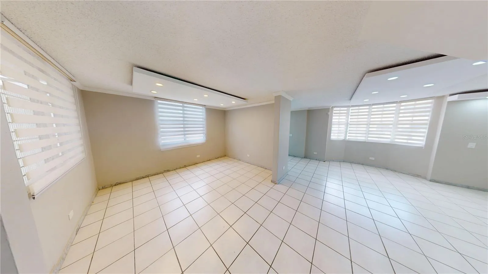 Formal living and dining areas featuring illuminated ceiling fascias and abundant natural light