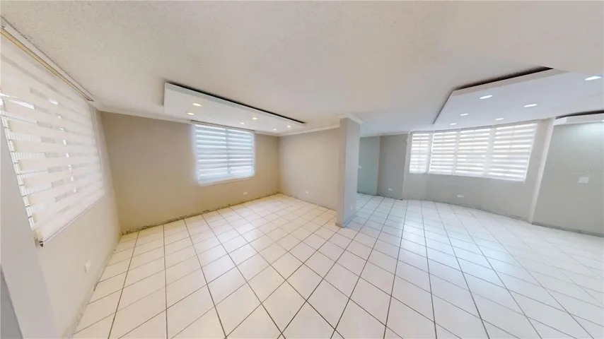 Formal living and dining areas featuring illuminated ceiling fascias and abundant natural light