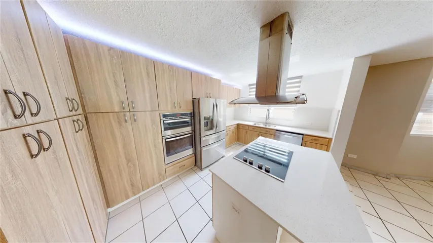 FULLY EQUIPPED KITCHEN WITH QUARTZ COUNTERTOPS, LIGHTING, COOKING ISLAND AND BREAKFAST AREA