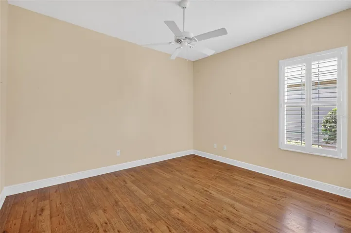 2ND GUEST ROOM WITH PLANTATION SHUTTERS, THE SAME LOVELY LAMINATE FLOORING, AND CEILING FAN.