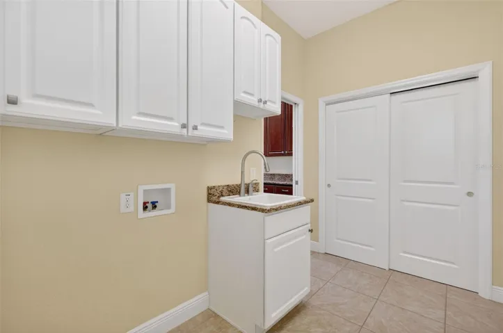 POCKET DOOR FROM THE KITCHEN TO THE LAUNDRY ROOM WITH LARGE PANTRY/CLOSET, BUILT-IN SINK AND EXTRA CABINET SPACE.