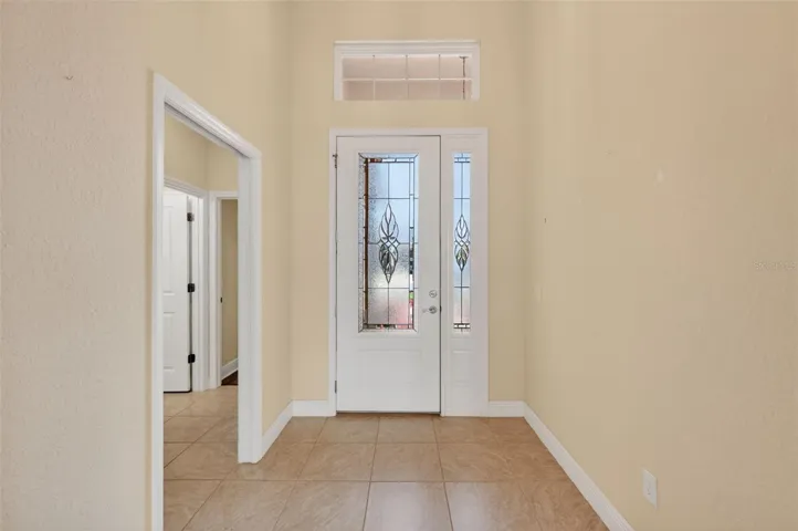 CERAMIC TILE FLOORING IN THE FOYER, HALLWAYS, AND THROUGHOUT THE MAIN LIVING AREA, KITCHEN, AND LAUNDRY.  THIS POCKET DOOR LEADS TO THE PRIVATE GUEST SUITE.