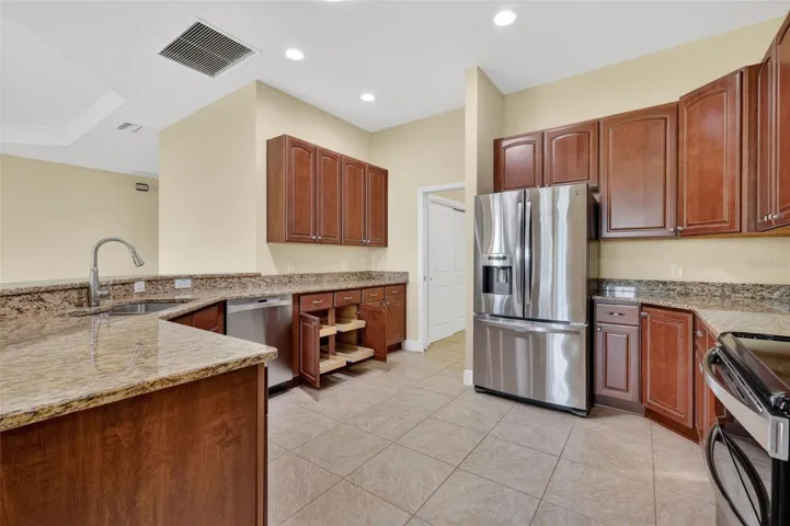 GRANITE COUNTER TOPS, LIGHT CHERRY CABINETRY, AND UPPER AND LOWER PULL OUT DRAWERS.