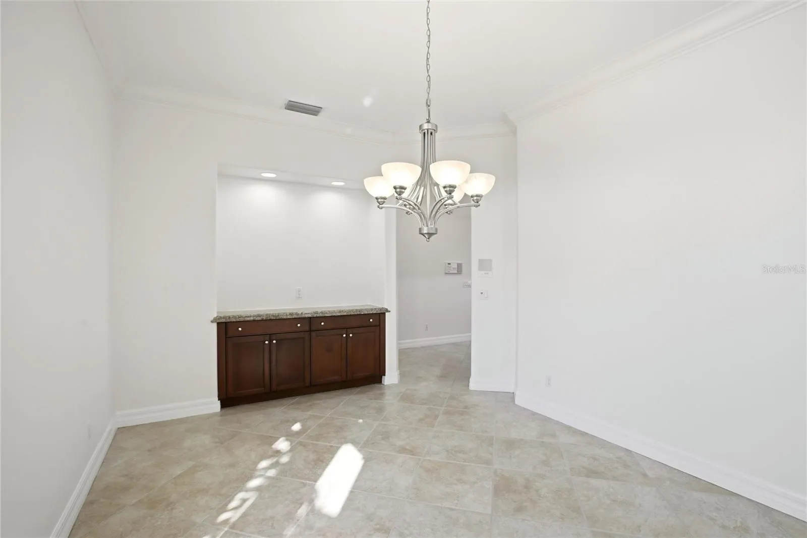 A separate dining room is conveniently located just off the kitchen and features built-in cabinetry, offering both elegance and functional storage.