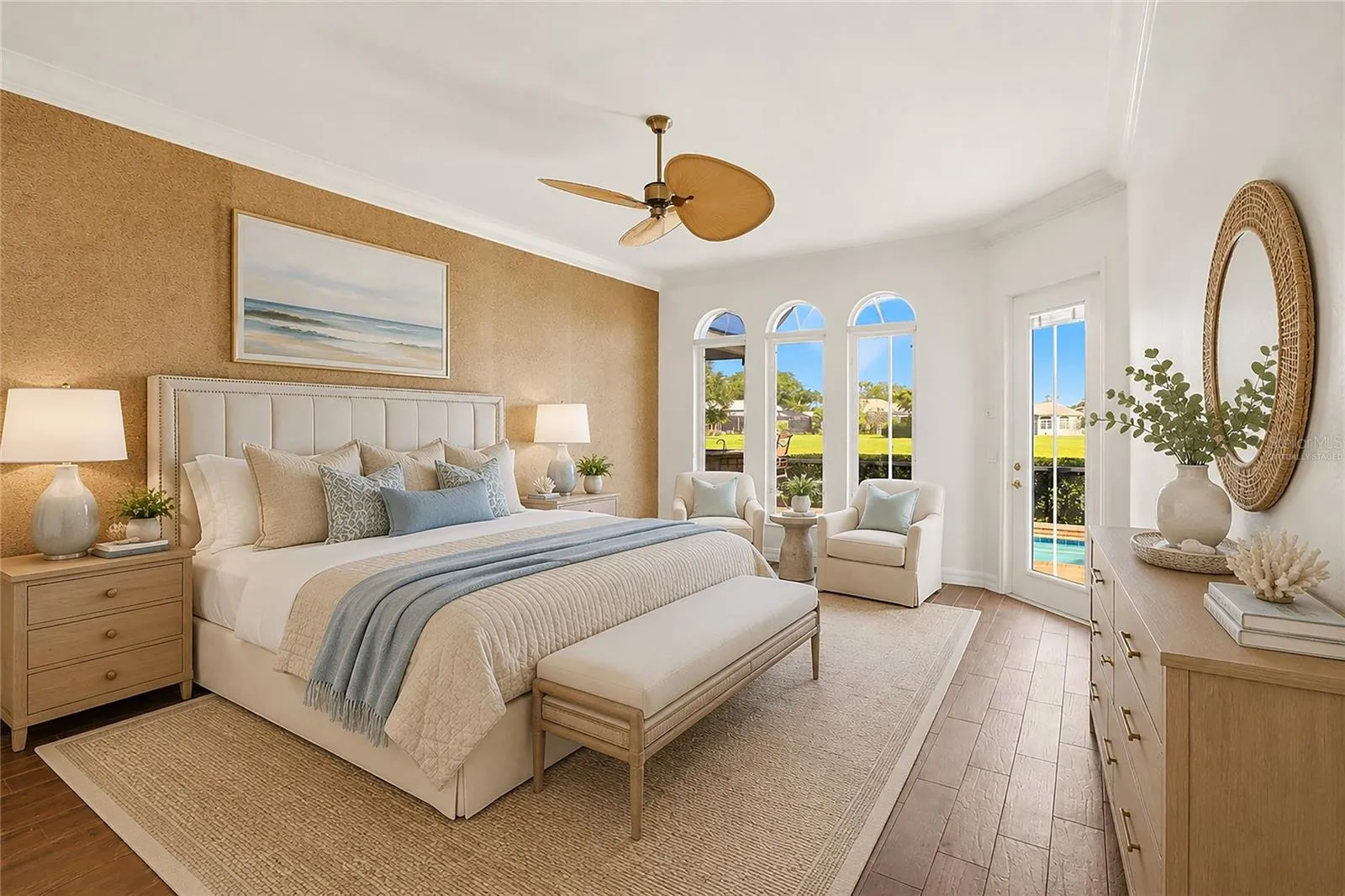This photo is virtually staged. The first-floor primary suite features direct access to the lanai and showcases peaceful views of the lake and pool.