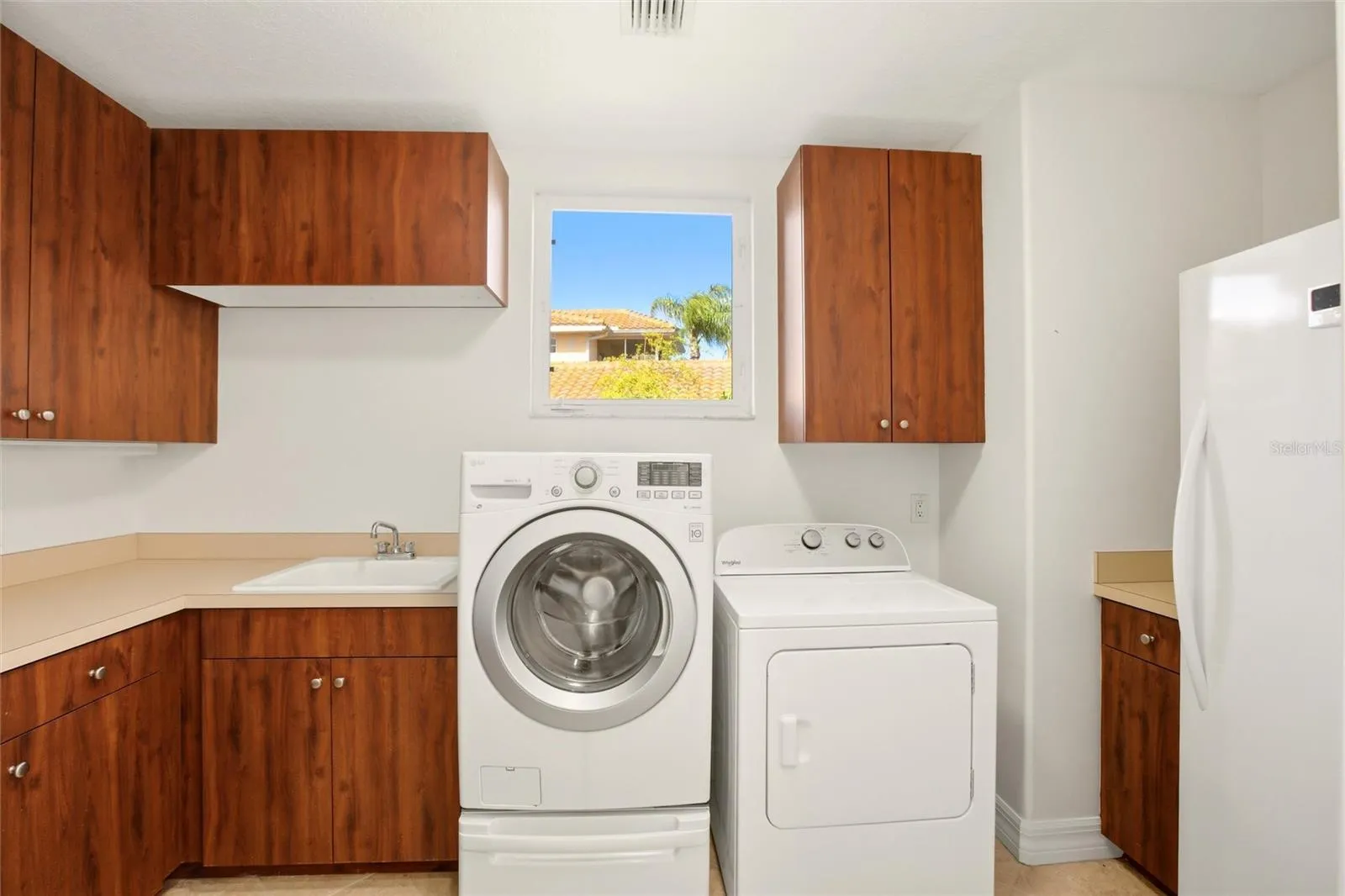 The first-floor laundry room offers abundant cabinetry, a generous folding counter workspace, and a stand-up deep freezer for added convenience and storage.