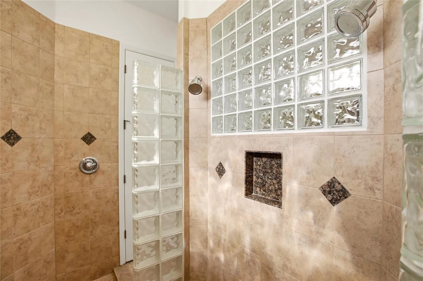 The primary bathroom features a soaking tub, split vanities with dedicated makeup counter space, a spacious walk-in shower with dual shower heads, a private water closet, and dual walk-in closets with custom organization.