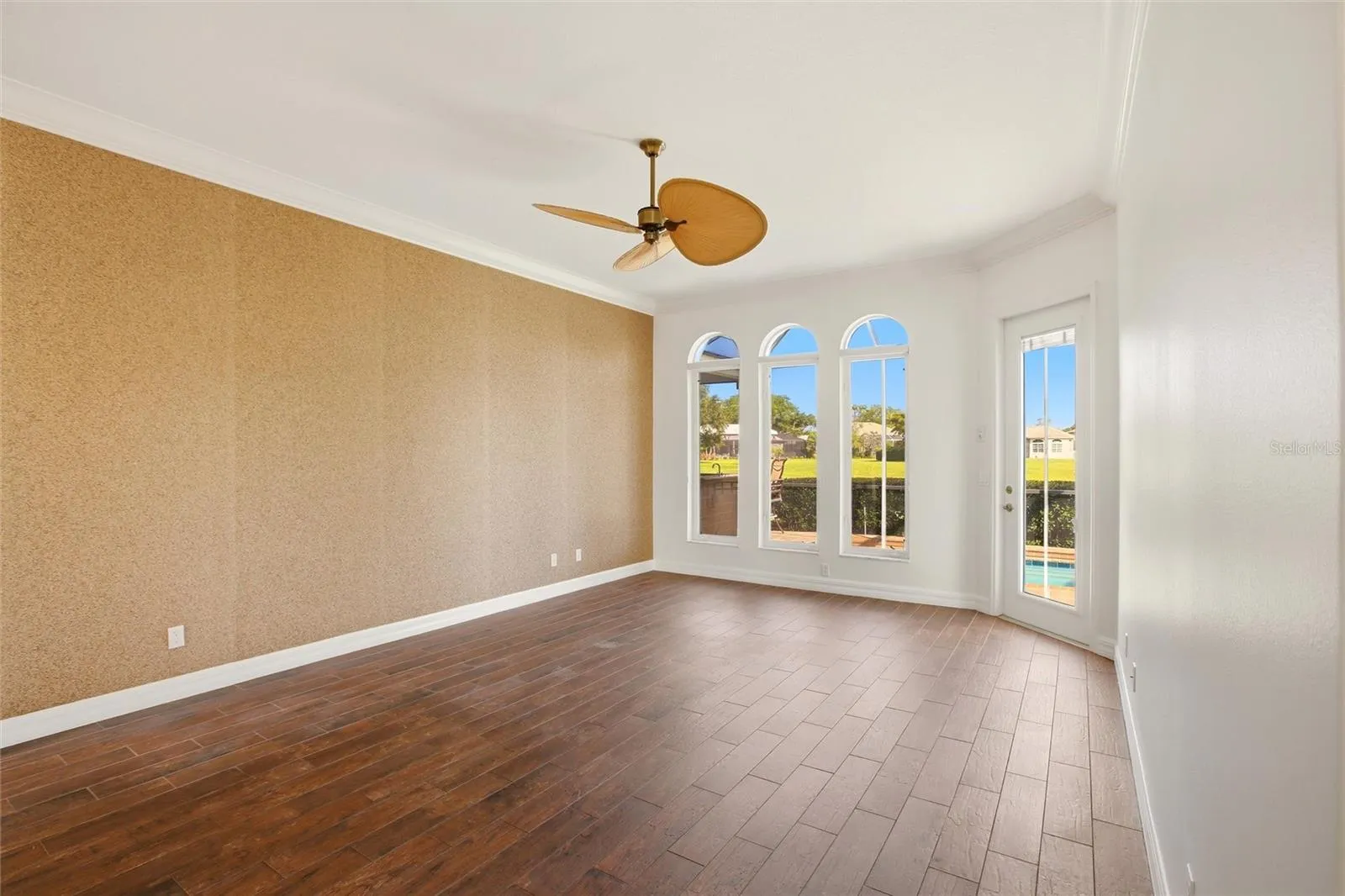 The first-floor primary suite features direct access to the lanai and showcases peaceful views of the lake and pool.
