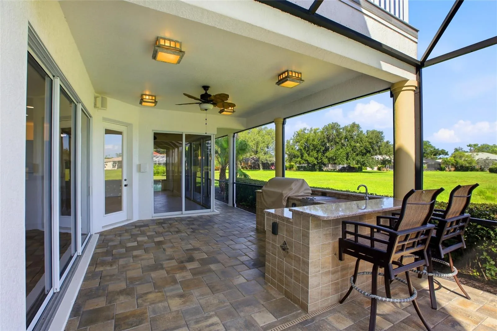 Enjoy resort-style living with a heated pool and spa, plus an outdoor kitchen complete with a gas grill, cooktop, and refrigerator — all set against picturesque golf course and water views with the peaceful backdrop of Misty Creek’s natural beauty and visiting deer.