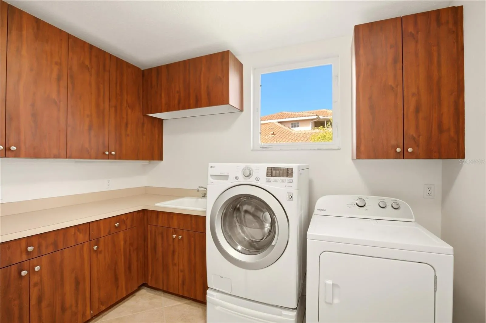 The first-floor laundry room offers abundant cabinetry, a generous folding counter workspace, and a stand-up deep freezer for added convenience and storage.