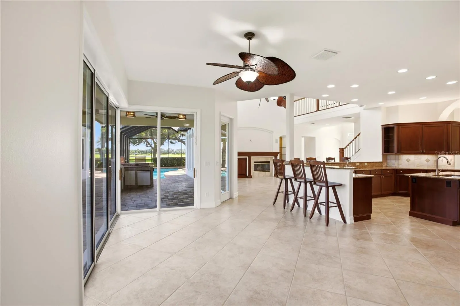 The kitchen offers an extensive breakfast bar and a comfortable casual dining area, along with generous counter space, dual sinks, double ovens, abundant cabinetry, and a spacious walk-in pantry.