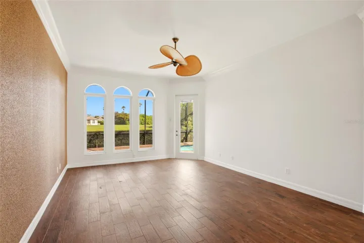 The first-floor primary suite features direct access to the lanai and showcases peaceful views of the lake and pool.