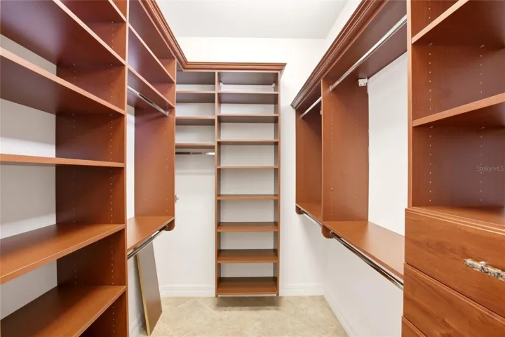 The primary bathroom features a soaking tub, split vanities with dedicated makeup counter space, a spacious walk-in shower with dual shower heads, a private water closet, and dual walk-in closets with custom organization.