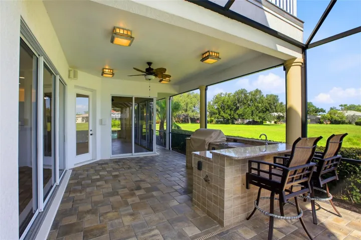 Enjoy resort-style living with a heated pool and spa, plus an outdoor kitchen complete with a gas grill, cooktop, and refrigerator — all set against picturesque golf course and water views with the peaceful backdrop of Misty Creek’s natural beauty and visiting deer.