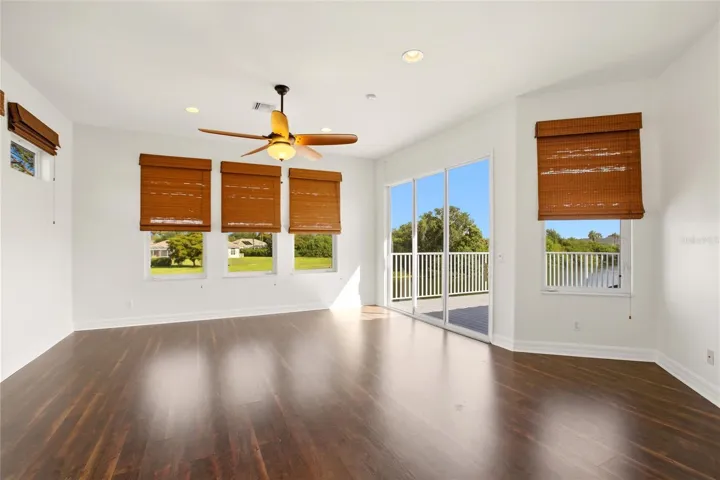 The spacious bonus room offers exceptional versatility, serving as an ideal playroom, guest quarters, media room, or workout space. It is well-appointed with a wet bar, refrigerator, washer and dryer, and a large storage closet, and opens through sliding glass doors to a private second-floor balcony overlooking the lake and golf course. A dumbwaiter provides convenient access from the kitchen below.