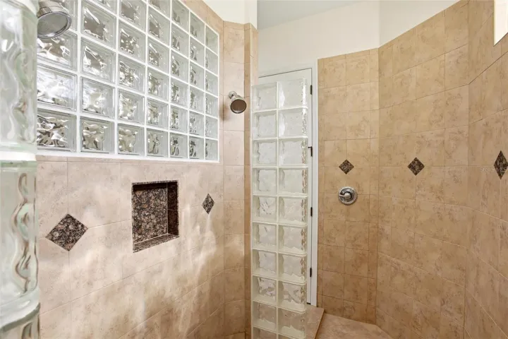 The primary bathroom features a soaking tub, split vanities with dedicated makeup counter space, a spacious walk-in shower with dual shower heads, a private water closet, and dual walk-in closets with custom organization.