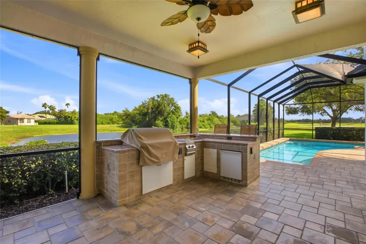 Enjoy resort-style living with a heated pool and spa, plus an outdoor kitchen complete with a gas grill, cooktop, and refrigerator — all set against picturesque golf course and water views with the peaceful backdrop of Misty Creek’s natural beauty and visiting deer.