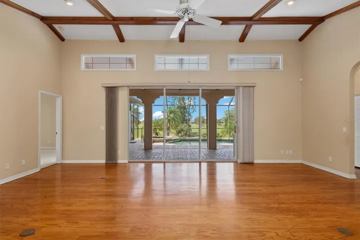 Wood flooring and beamed ceiling with transom windows