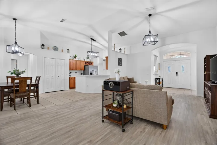 Entire view of the dining, living and kitchen facing the double door entryway