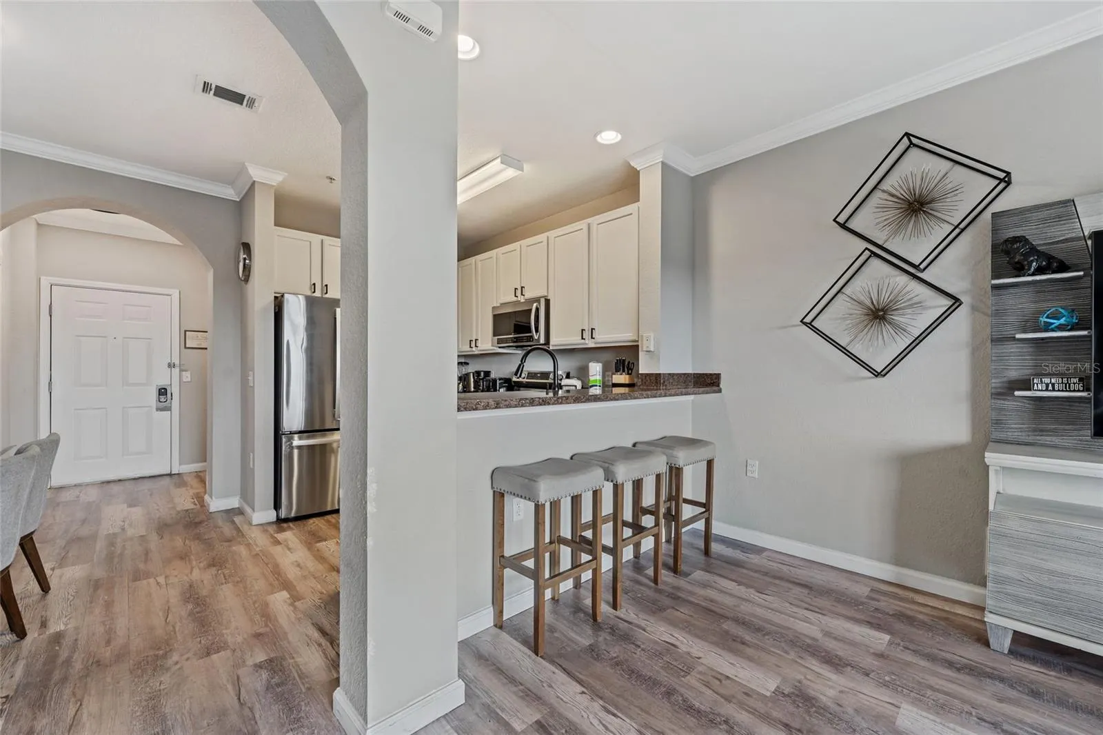 Kitchen and breakfast bar with stools from living area