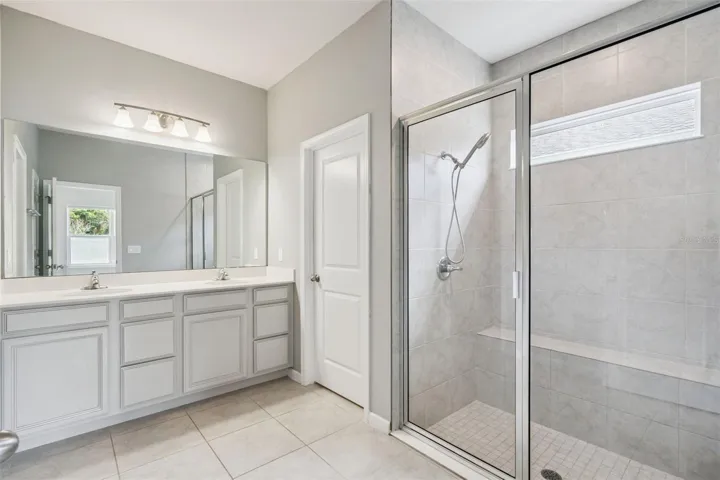 Large show with built-in bench and glass shower door