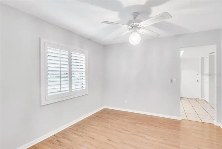 Dining area with beautiful hardwood floors and plantation style shutters.