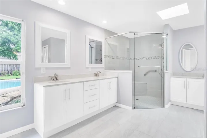 Newly remodeled primary suite bathroom with modern tile, fixtures, and granite.