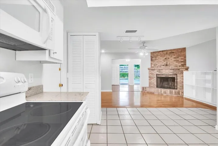 Kitchen to living area with beautiful brick fireplace.