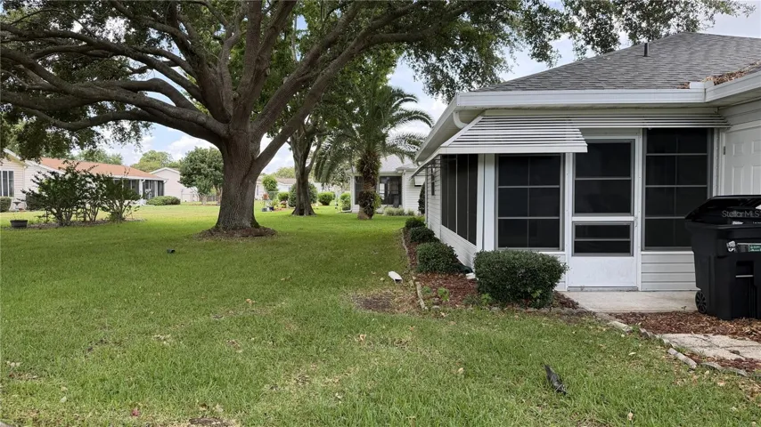 Backyard view with enclosed lanai and mature shade tree