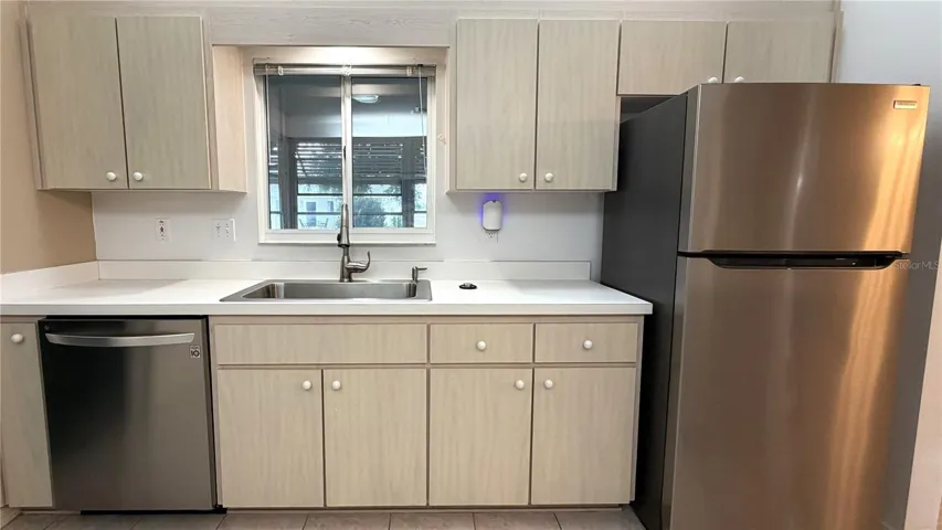 Kitchen with stainless appliances, sink window, and cabinet storage