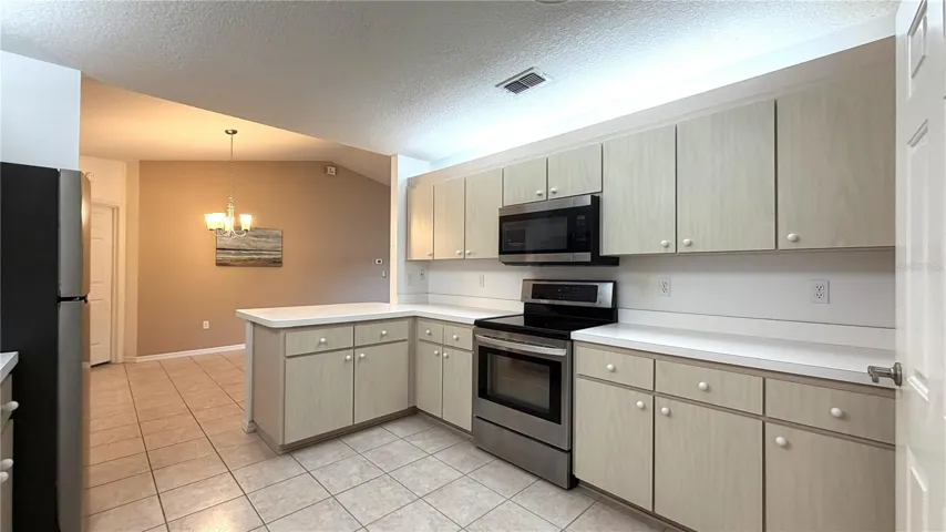 Kitchen view toward dining area with tile flooring