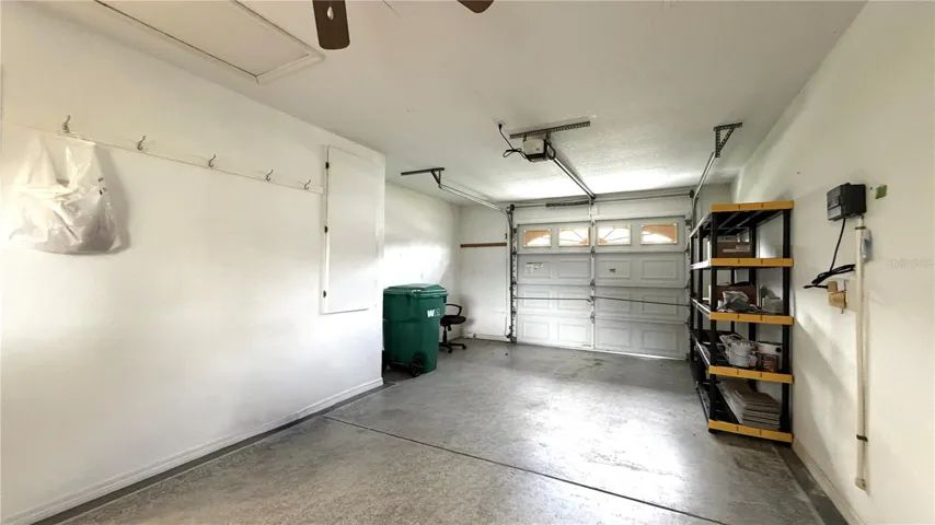 Extended one-car garage with storage shelving and workspace area
