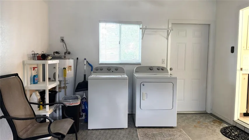 Garage laundry area with washer, dryer, utility area, and kitchen access