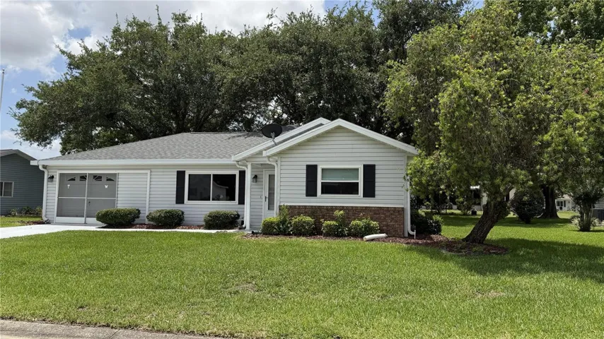 Front exterior view with mature shade tree and landscaped yard