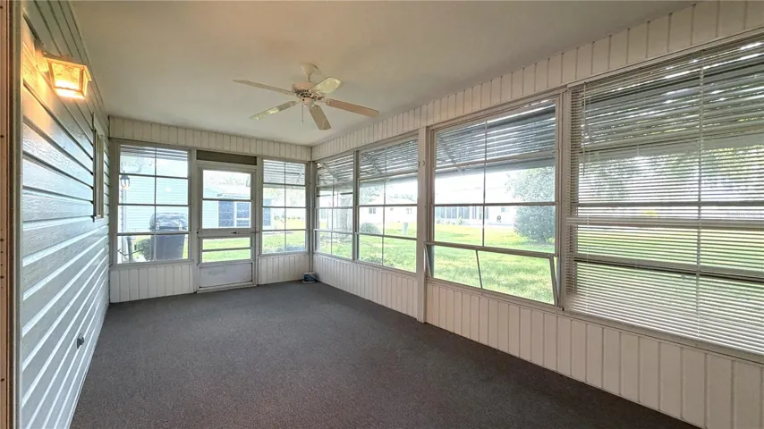 Enclosed lanai with window wall and backyard views